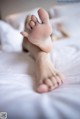 A woman laying on a bed with her feet up.