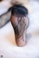 A close up of a woman's legs in fishnet stockings.