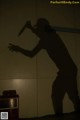 A shadow of a man holding a knife on a wall.