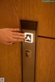 A woman's hand is pressing a button on an elevator.