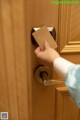 A person opening a door with a business card in their hand.