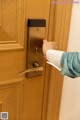 A person opening a door with a paper towel.