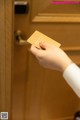 A person holding a business card in front of a door.