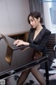 A woman sitting at a desk using a laptop computer.