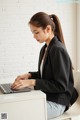 A woman sitting at a desk using a laptop computer.