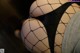 A close up of a woman's butt in fishnet stockings.