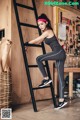 A woman leaning on a ladder in a garage.