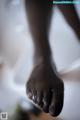 A close up of a person's foot on a bed.