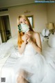 A woman in a wedding dress holding a bouquet of flowers.