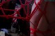 A close up of a person tied up with red string.