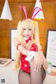 A woman in a bunny costume sitting on a desk.